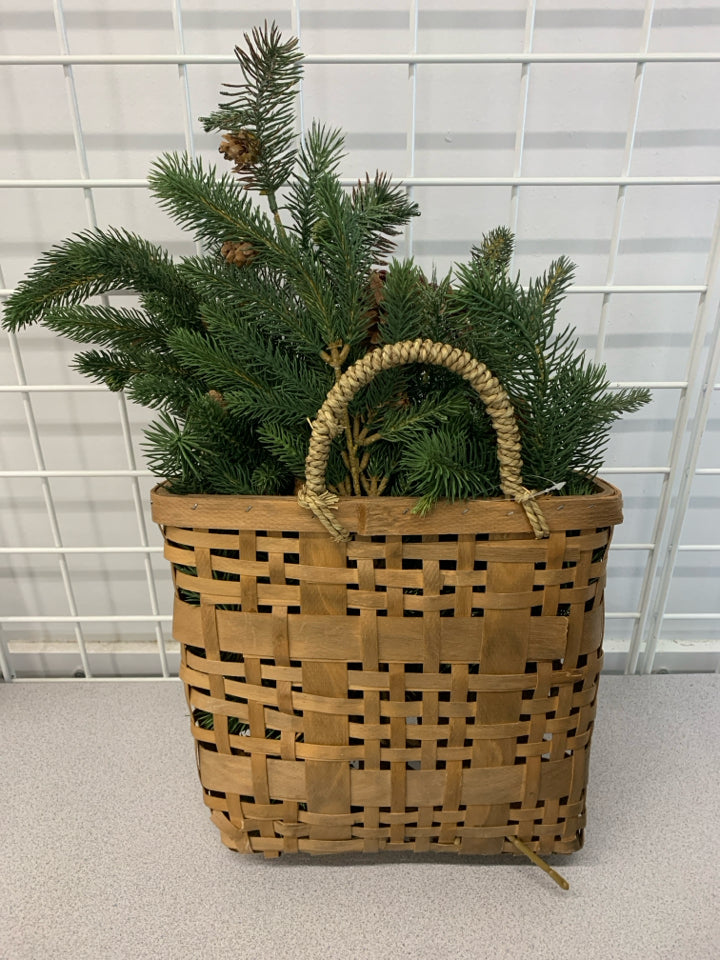 BROWN WOVEN WALL BASKET W/ FAUX PINE BRANCHES/PINECONES & BERRIES.