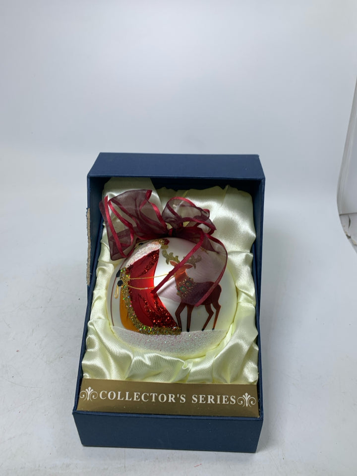 LARGE WHITE ORNAMENT W/ SANTA WALKING REINDEER IN BOX.