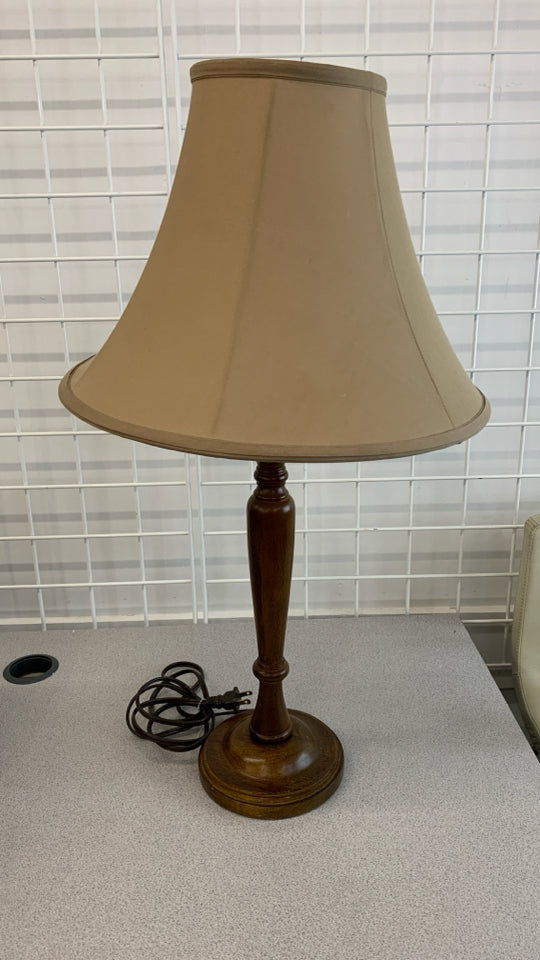 TALL WOODEN TABLE LAMP W/BEIGE SHADE.