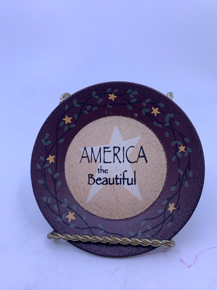 PRIMITIVE "AMERICA THE BEAUTIFUL" MAROON ROUND WALL HANGING.
