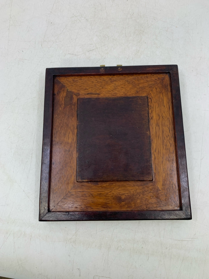 WOOD WALL HANGING W/ 2 MEN LOOKING AT EACHOTHER POTTERY PIECE.