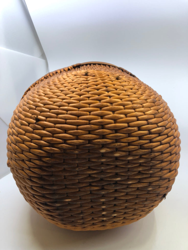 SMALL ROUND ORANGE TIGHT WEAVE BASKET W/ 3 CROSSED HANDLE.