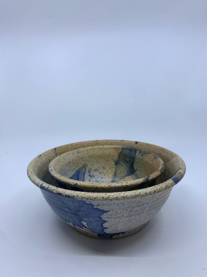 2 NESTING TAN AND BLUE POTTERY BOWLS.