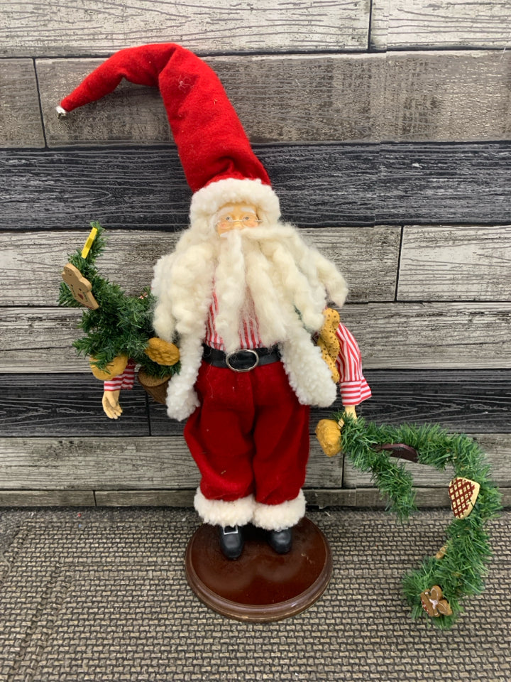 SANTA HOLDING CHRISTMAS TREE.