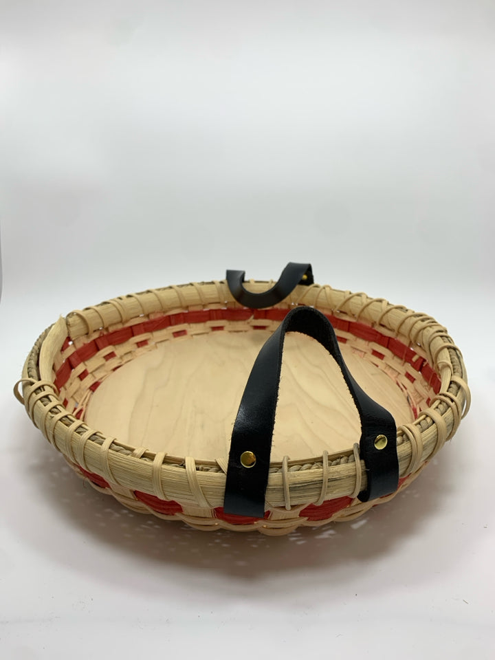 ROUND WOVEN BASKET TRAY W/BLACK FAUX LEATHER HANDLES.