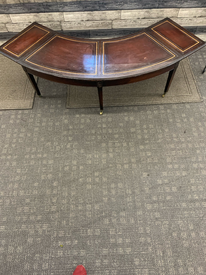 VTG DARK WOOD CRESCENT SHAPE COFFEE TABLE ON WHEELS.