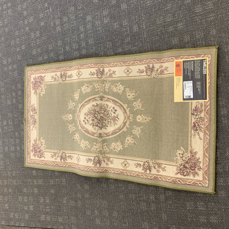 GREEN RUG W/FLORAL MEDALLION DESIGN.
