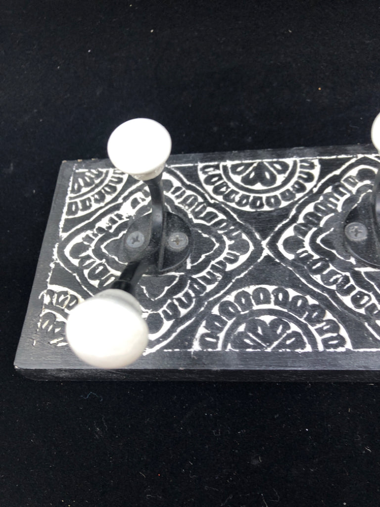BLACK 3 HOOK  WALL ART W/ CARVED WHITE DETAILS.