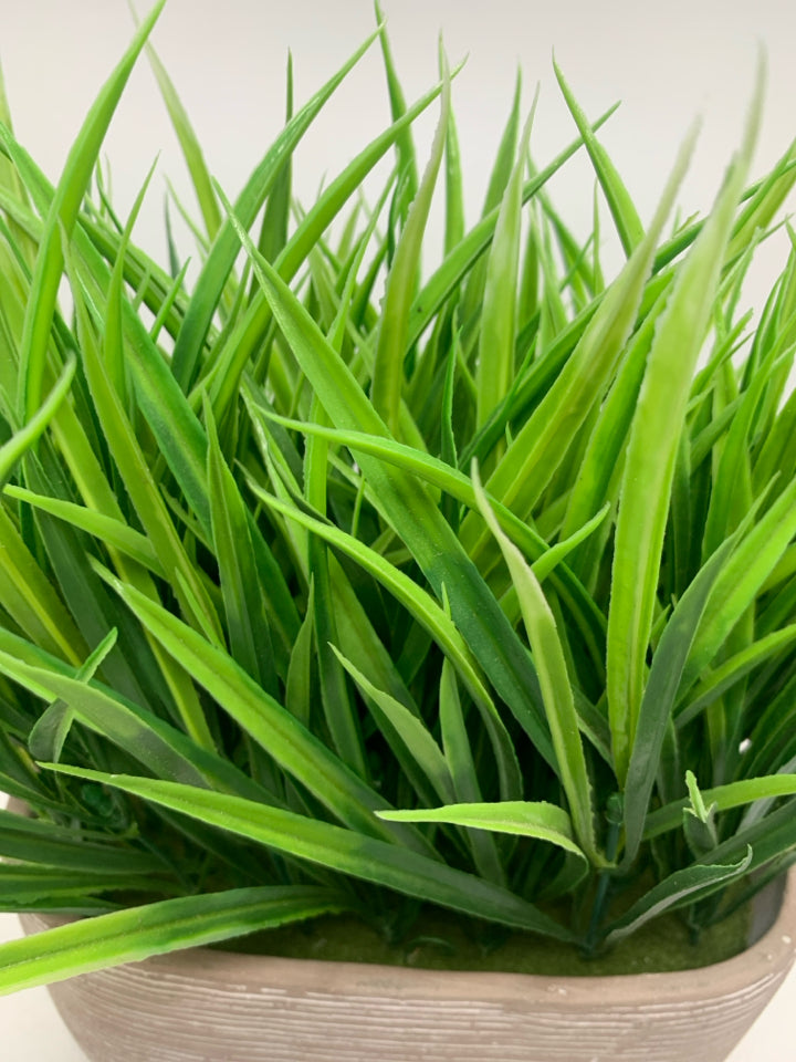 FAUX GRASS IN PLANTER.