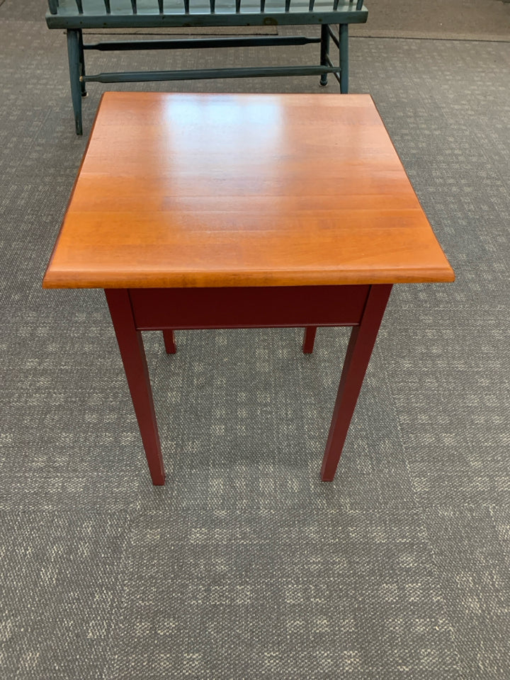 CHERRY WOOD SIDE TABLE W/DRAWER AND RED PAINTED LEGS.