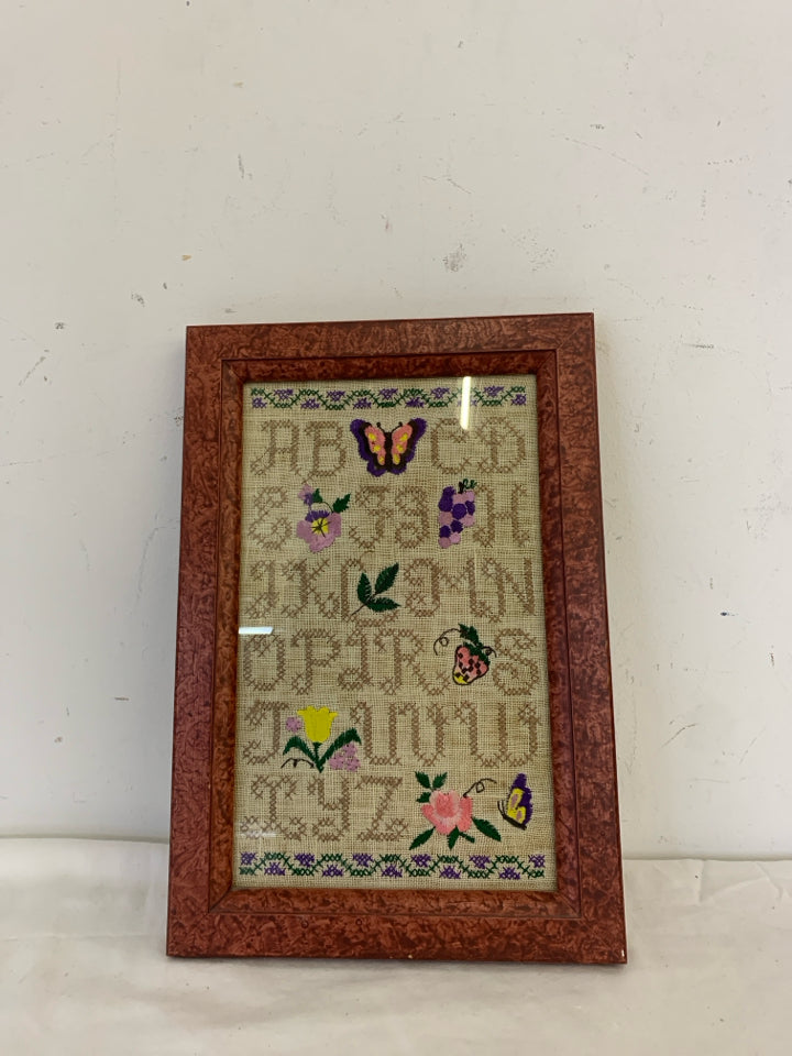 ABC'S NEEDLEPOINT SAMPLER IN RED FRAME WALL HANGING.