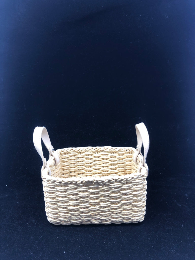 SMALL FLEXIBLE WOVEN BASKET W/ BEIGE FAUX LEATHER HANDLES.