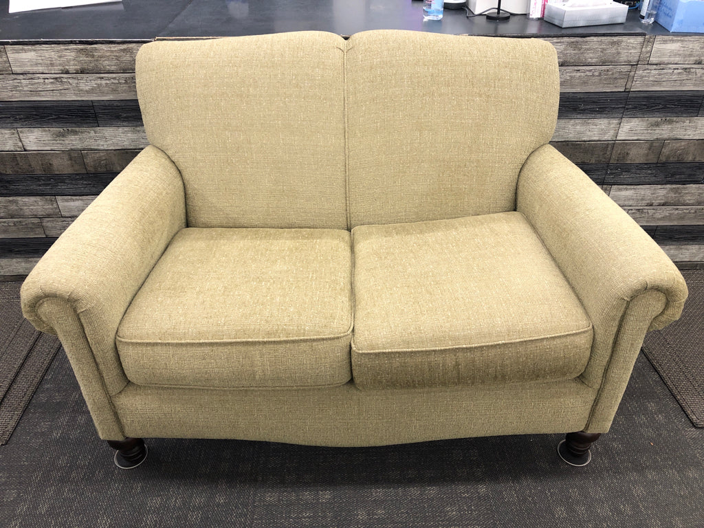 ARTICHOKE GREEN LOVE SEAT W/ BROWN WOOD LEGS.