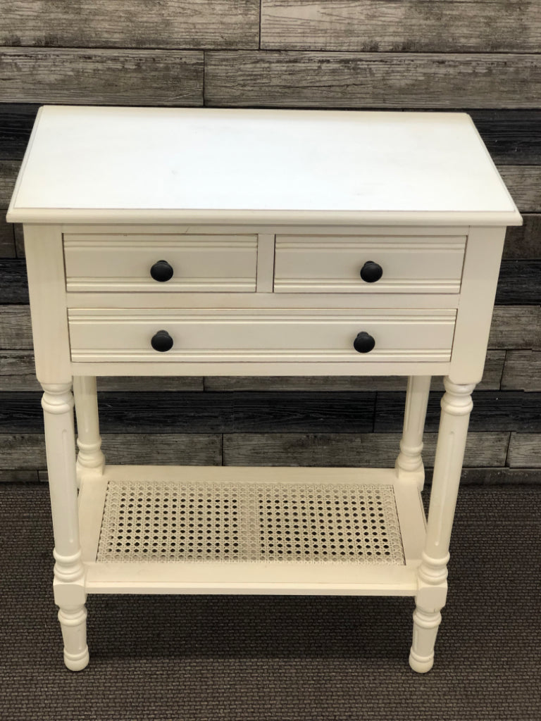 WHITE WOOD SIDE TABLE W/3 DRAWERS AND CANE BOTTOM SHELF.