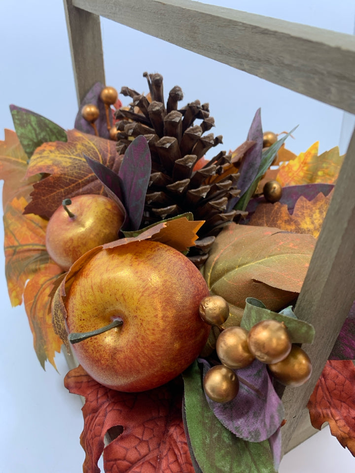 FAUX FALL FOLIAGE AND APPLES IN WOODEN BASKET.