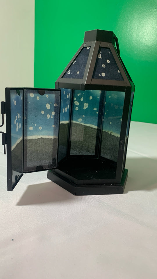 BLACK METAL HEXAGON SHAPED LANTERN W/ PAINTED PANES.