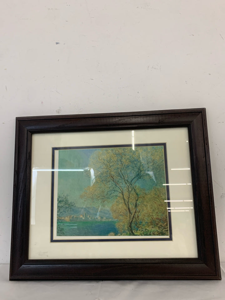 TREE CITYSCAPE WALL HANGING IN BROWN FRAME.