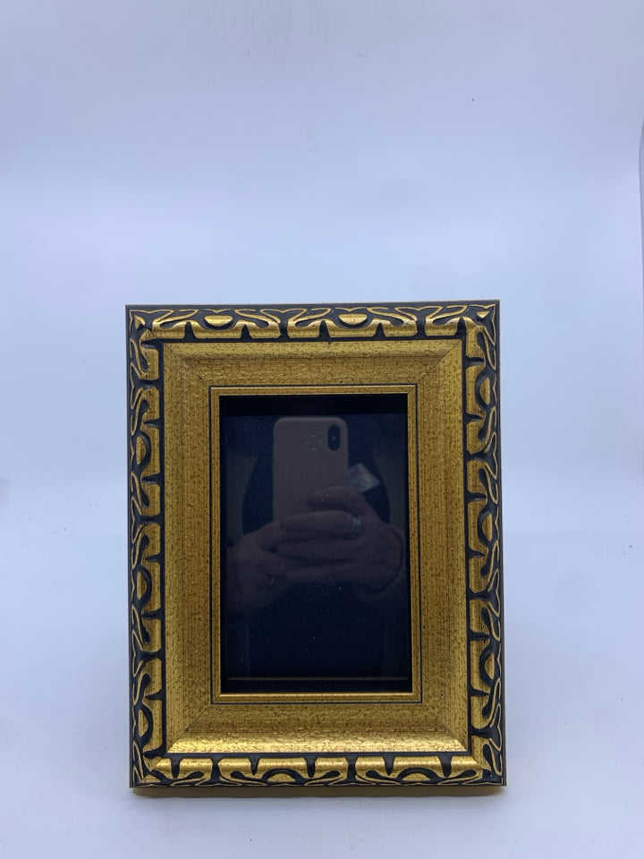 GOLD PHOTO FRAME W/ BLACK DESIGNS.