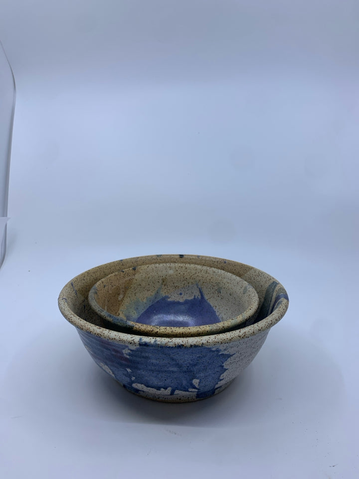 2 NESTING TAN AND BLUE POTTERY BOWLS.