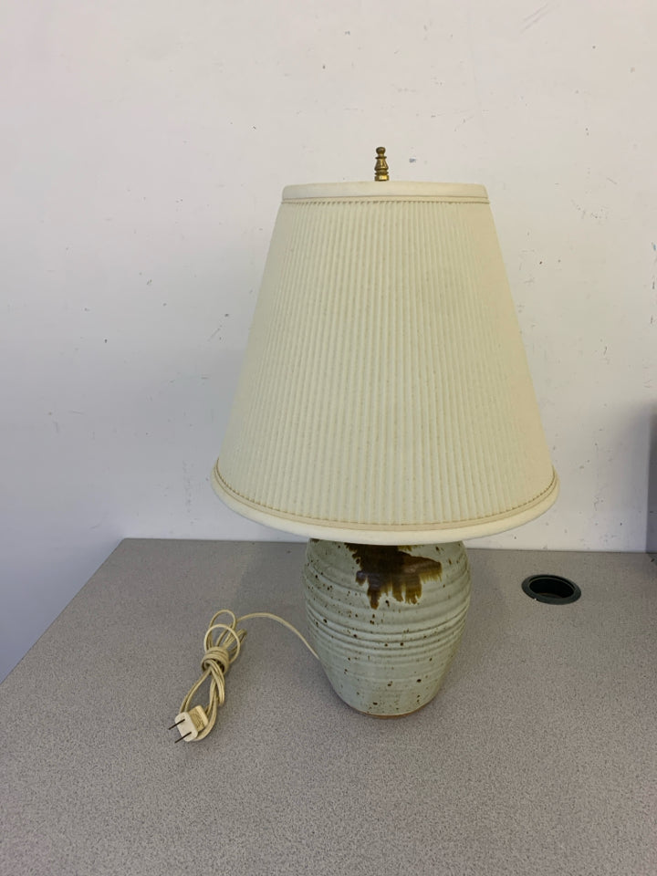 CREAM W/ BROWN SPECKLES POTTERY BASE LAMP W/ WHITE RIBBED SHADE.