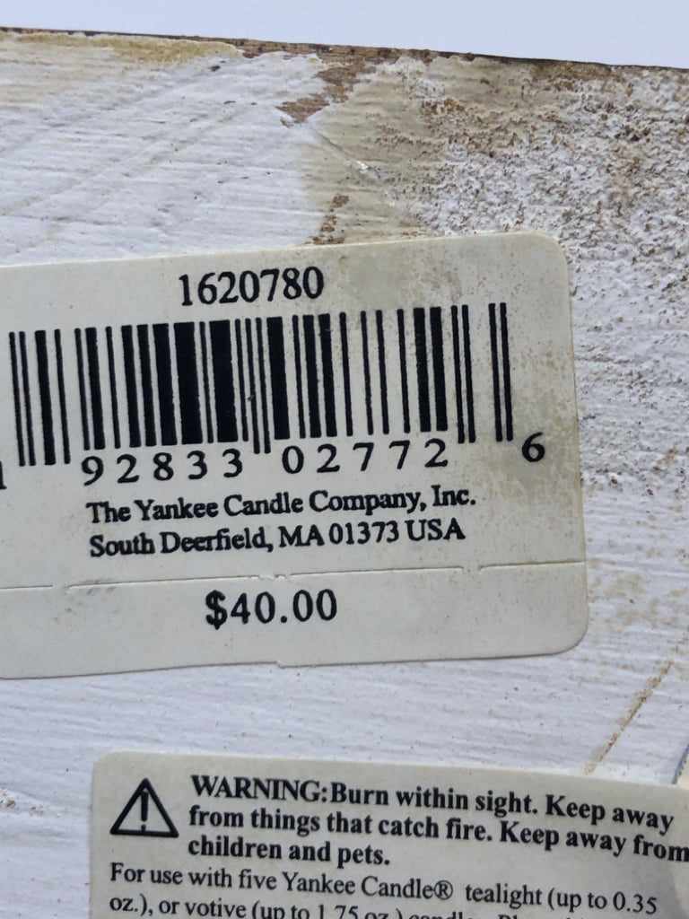 5 METAL CANDLE HOLDERS ON DISTRESSED WOOD BLOCK.