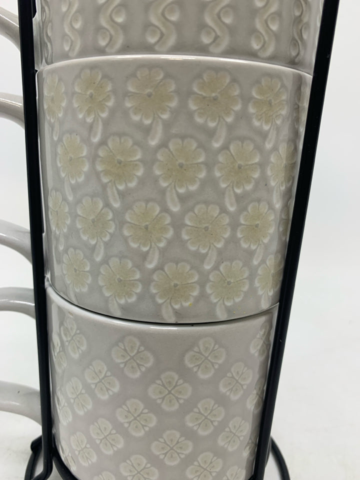 4 STACKING EMBOSSED MUGS IN STAND.