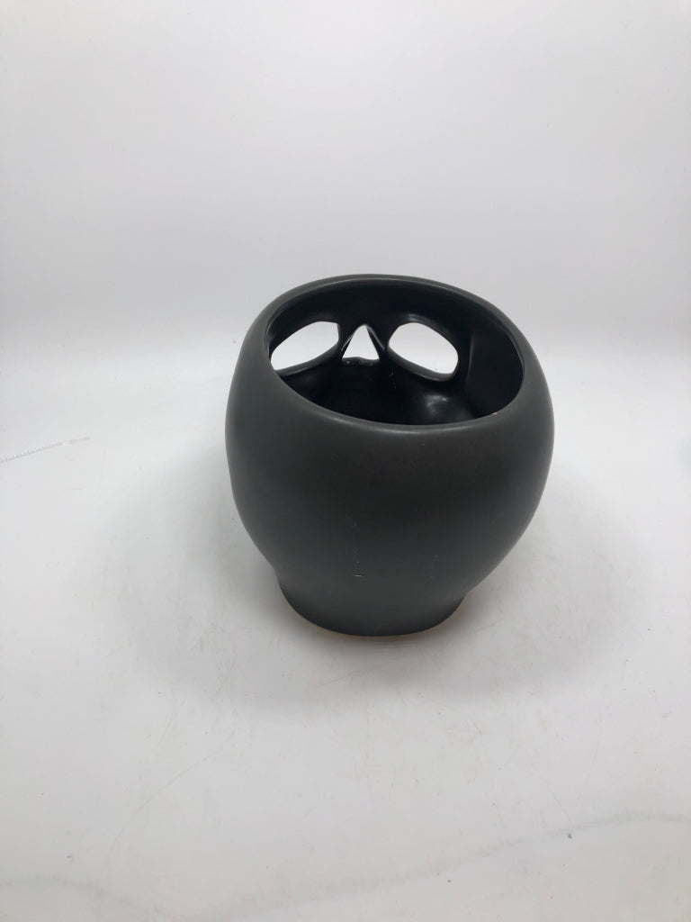 BLACK CERAMIC SKULL CANDLE HOLDER.