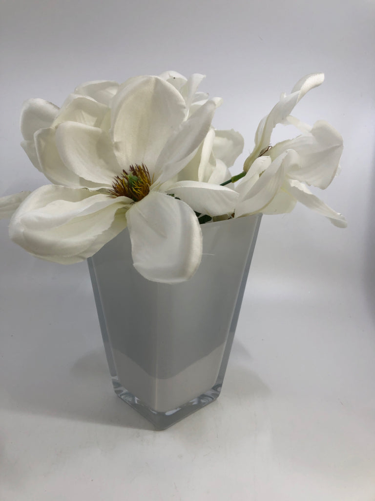 FAUX MAGNOLIA FLOWERS IN WHITE GLASS VASE.