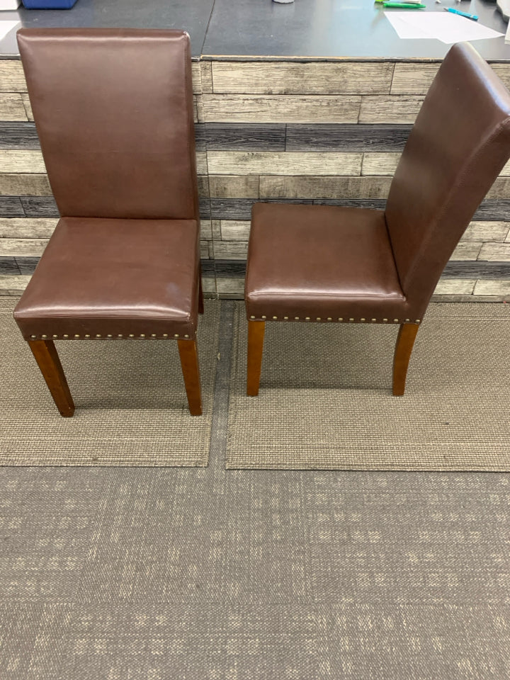 2 BROWN FAUX LEATHER CHAIRS W/ STUDDED EDGE.