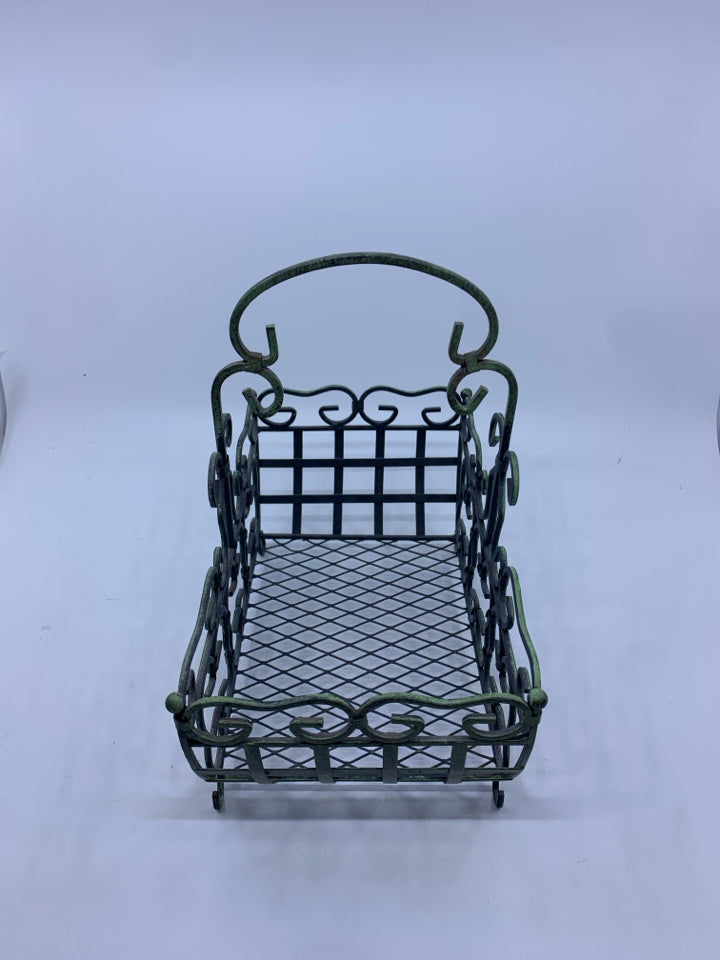 DISTRESSED FOOTED METAL BASKET W/ GREEN TINT SCROLL DESIGN.