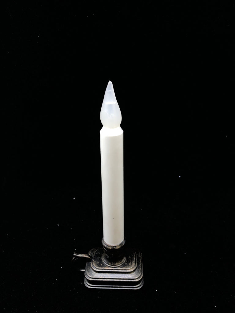 WHITE CANDLE STICK PLASTIC BRONZE HANDLE BATTERY OPERATED.