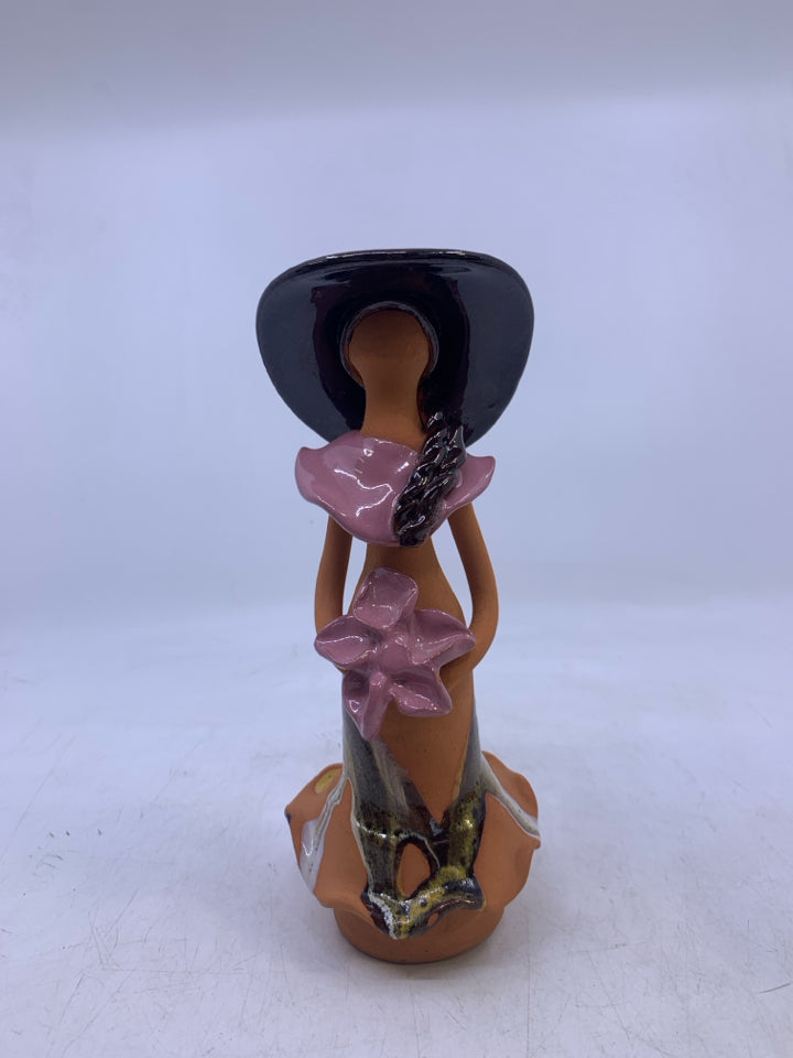 CLAY FACELESS WOMAN BROWN HAT HOLDING PINK FLOWERS.