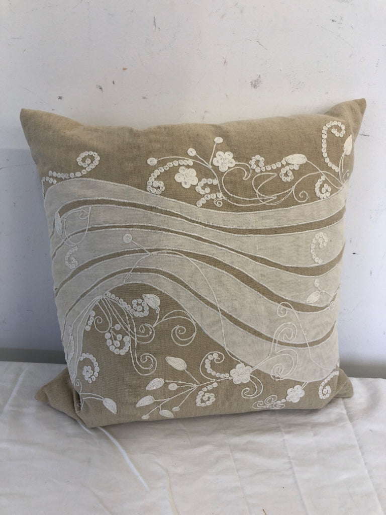 TAN PILLOW + WHITE FABRIC DESIGNS/FLOWERS.