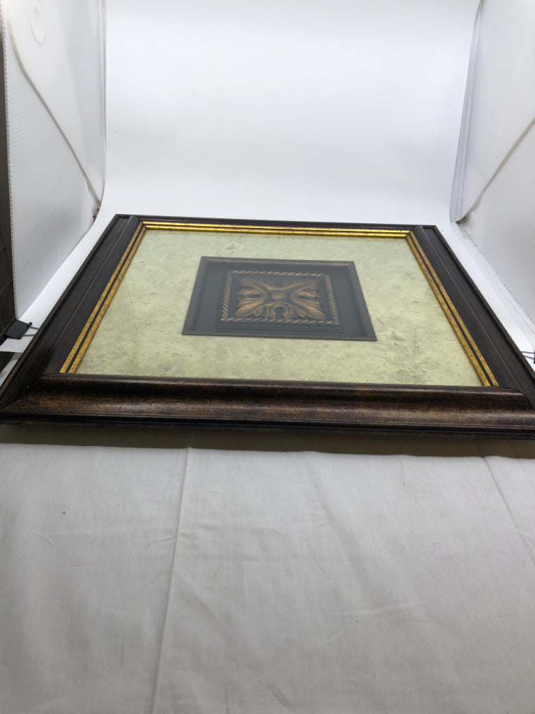 GOLD MEDALLION IN DARK BROWN FRAME.