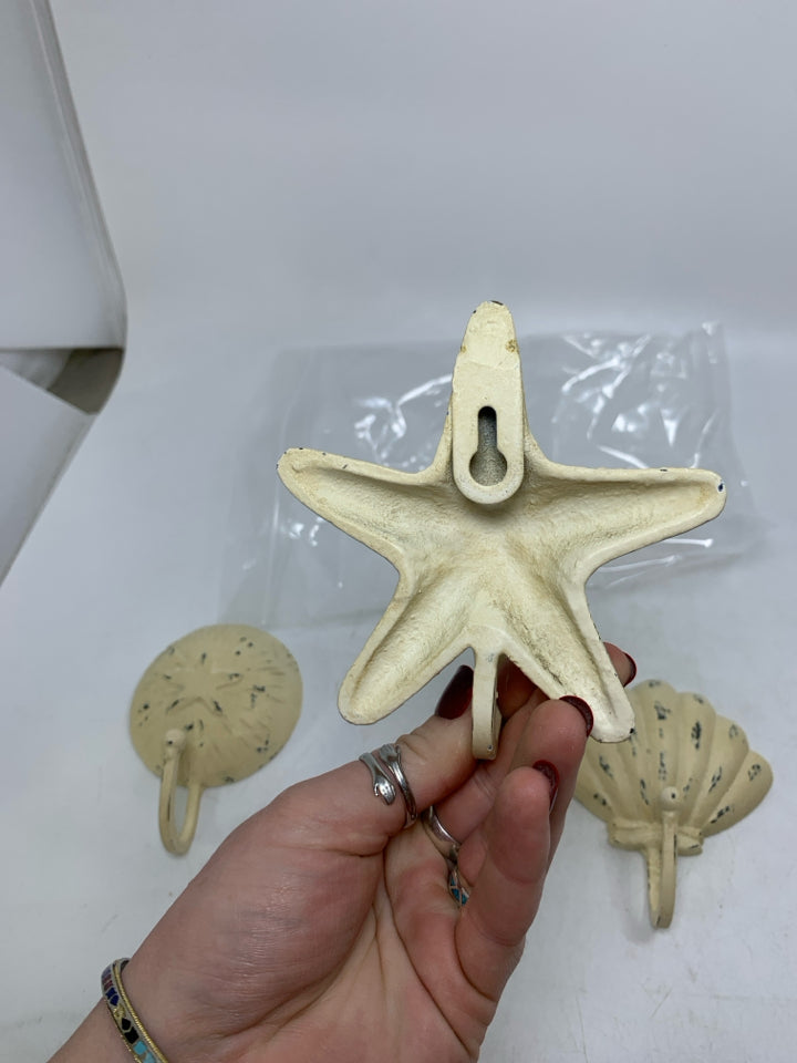 3 DISTRESSED CREAM METAL WALL HOOKS SEA THEMED IN BAG.