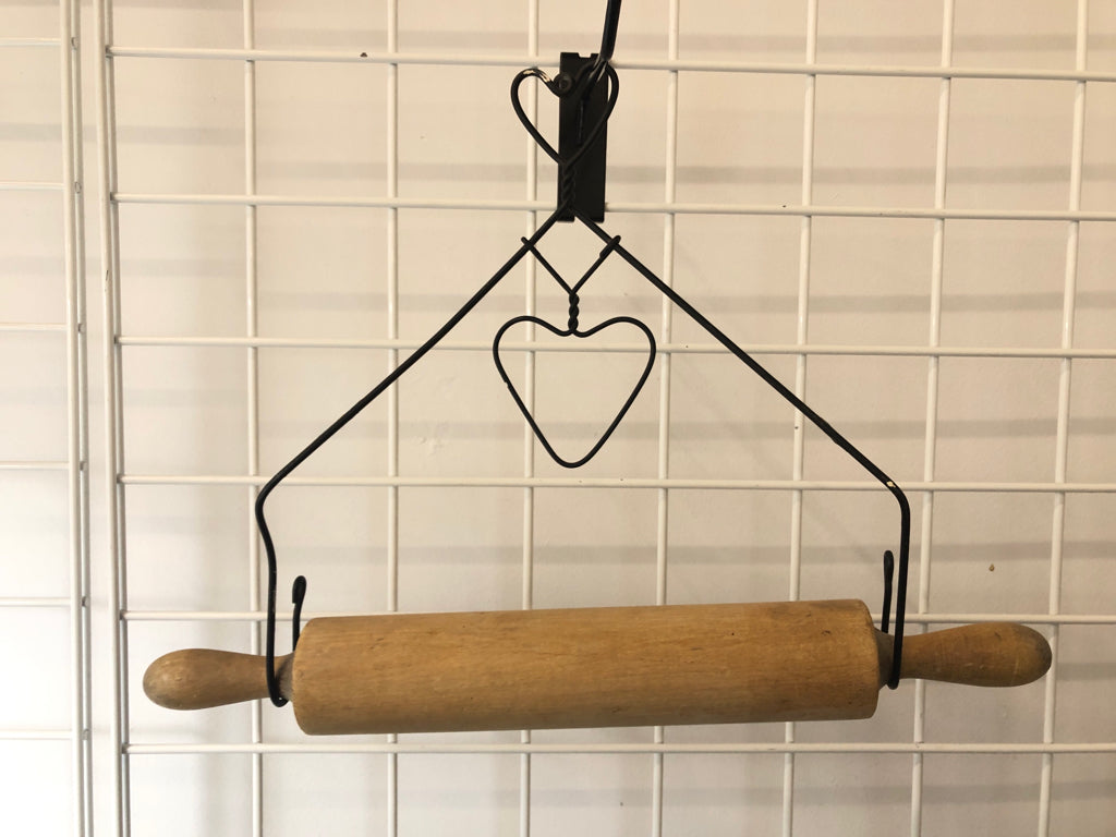 PRIMITIVE ROLLING PIN IN METAL WIRE HOLDER.