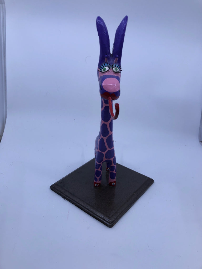 PINK AND PURPLE GIRAFFE ON WOOD STAND.