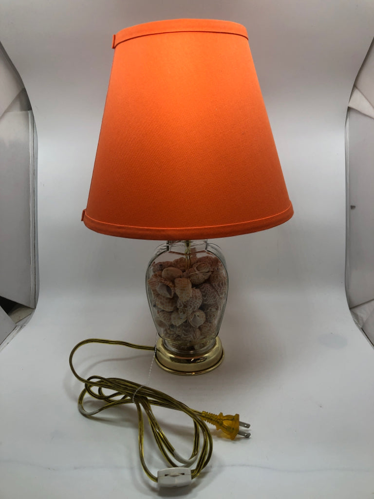 SEASHELL FILLED LAMP W/ORANGE SHADE.