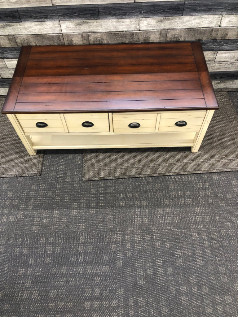 CREAM AND DARK WOOD TOP DISTRESSED COFFEE TABLE.