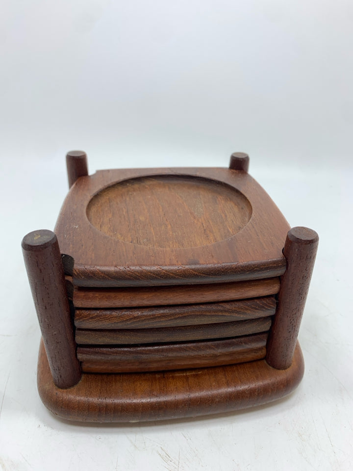 6 CARVED WOODEN COASTERS IN HOLDER.