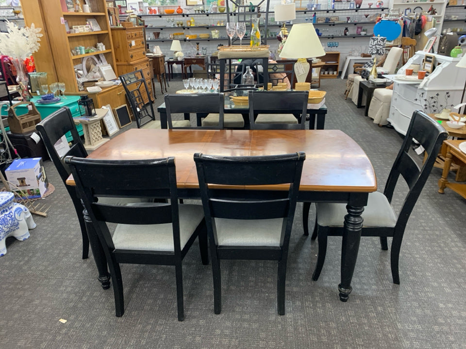 WOOD DINNING TABLE W/ BLACK LEGS 6 CHAIRS W/ GREY UPHOLSTERED SEATS.