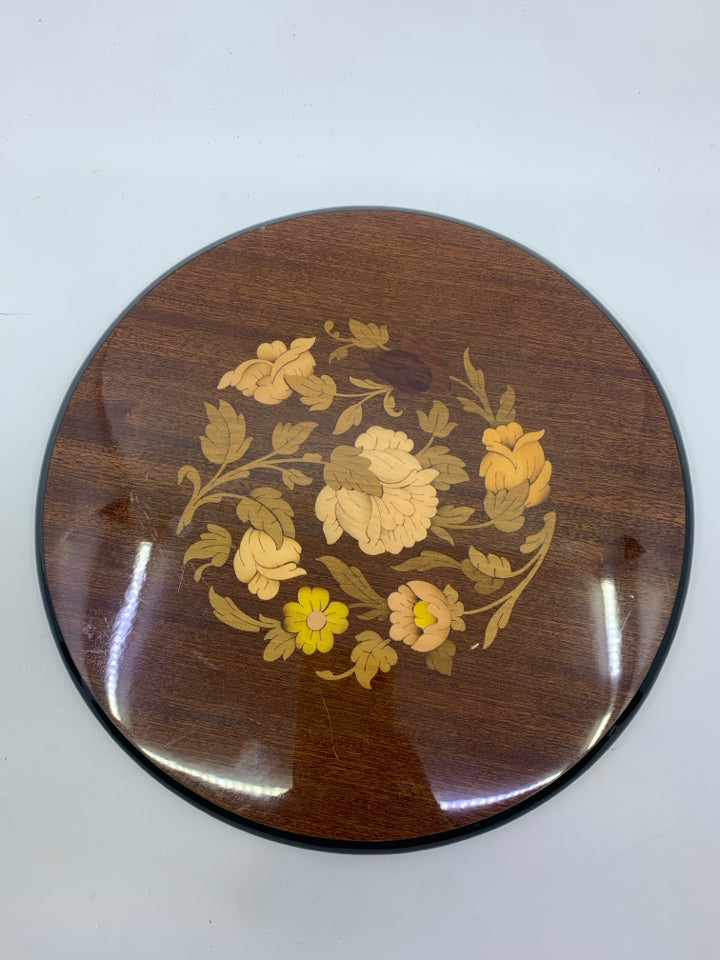 INLAID FACTORY WOOD TRIVET W/ FLORAL DESIGN IN CENTER.