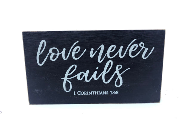 "LOVE NEVER FAILS"  BLACK WOOD WALL HANGING.