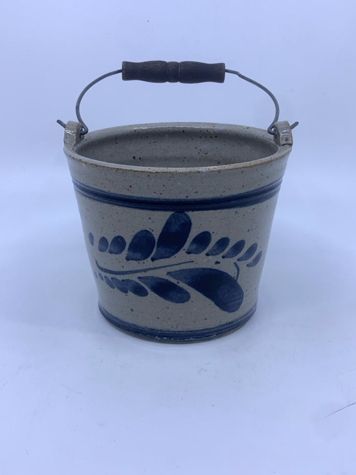 POTTERY W/BLUE AND METAL HANDLE.