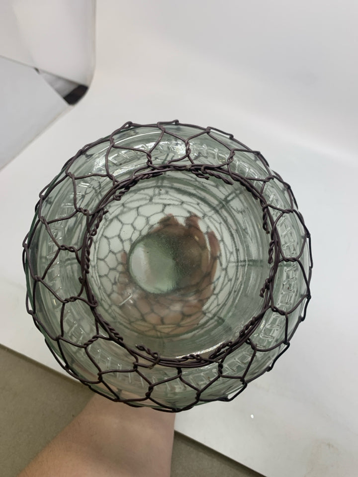 GLASS JUG W/ CHICKEN WIRE COVERING.
