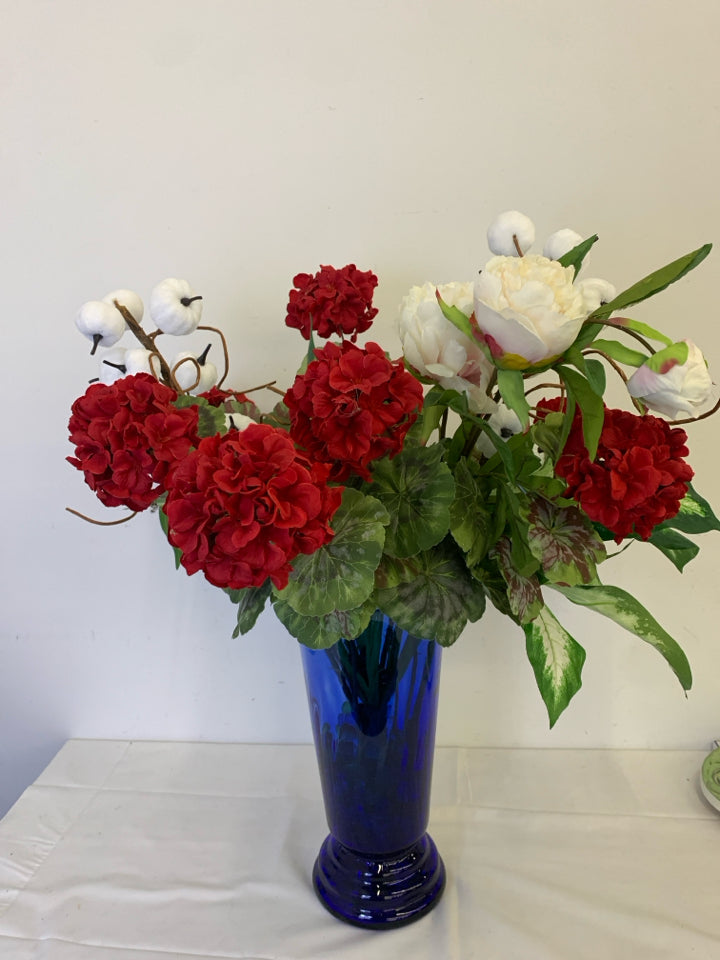 TALL BLUE VASE W PUMPKIN AND FAUX RED AND WHITE FLORAL.