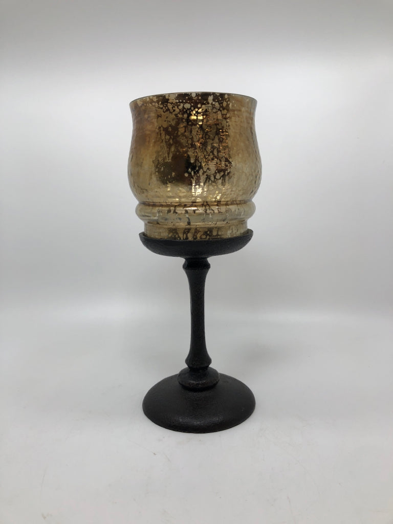 GOLD MERCURY GLASS CANDLE HOLDER ON BROWN METAL BASE.