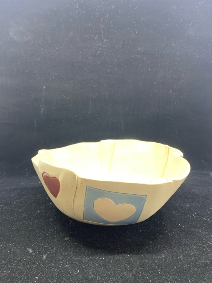 CREAM SPECKLED POTTERY BOWL W/ ASSORTED HEARTS FOLDED EDGES.