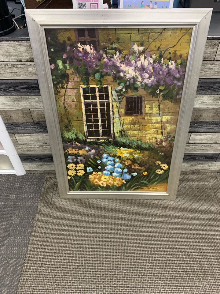 LARGE FLOWER GARDEN IN FRONT OF BUILDING PRINT IN SILVER FRAME.