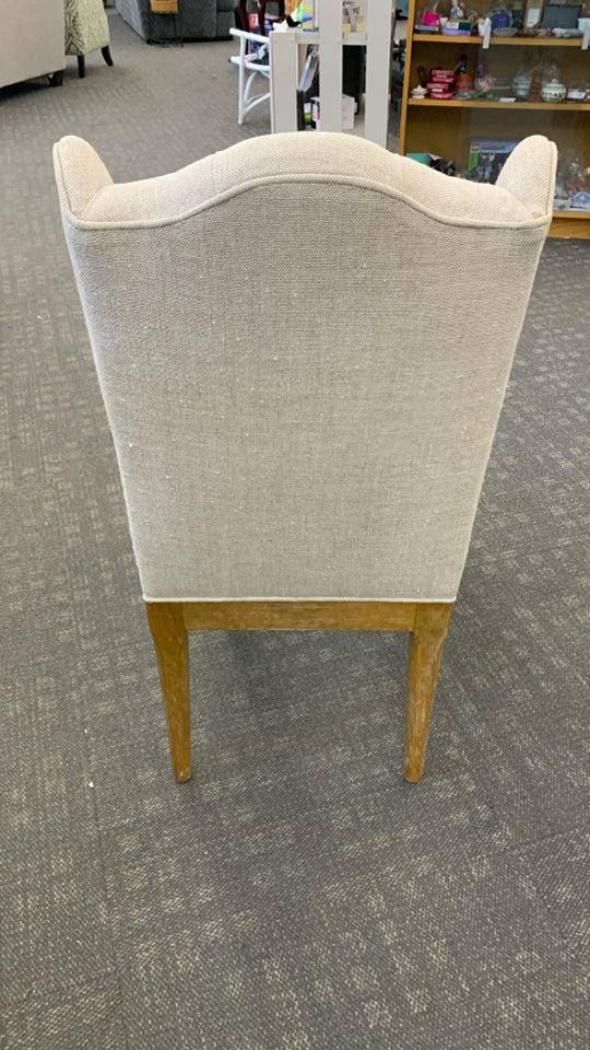 WHITE FABRIC CHAIR W/BROWN WOOD LEGS.